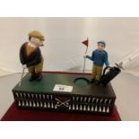 A CAST IRON MONEY BOX WITH A MOVABLE GOLFER AND CADDY