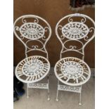 A PAIR OF ORNATE CAST IRON GARDEN CHAIRS