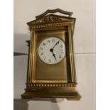 A BRASS CARRIAGE CLOCK WITH GABLED TOP WITH GLASS VIEWING PANE, FRENCH MECHANICAL MOVEMENT AND KEY