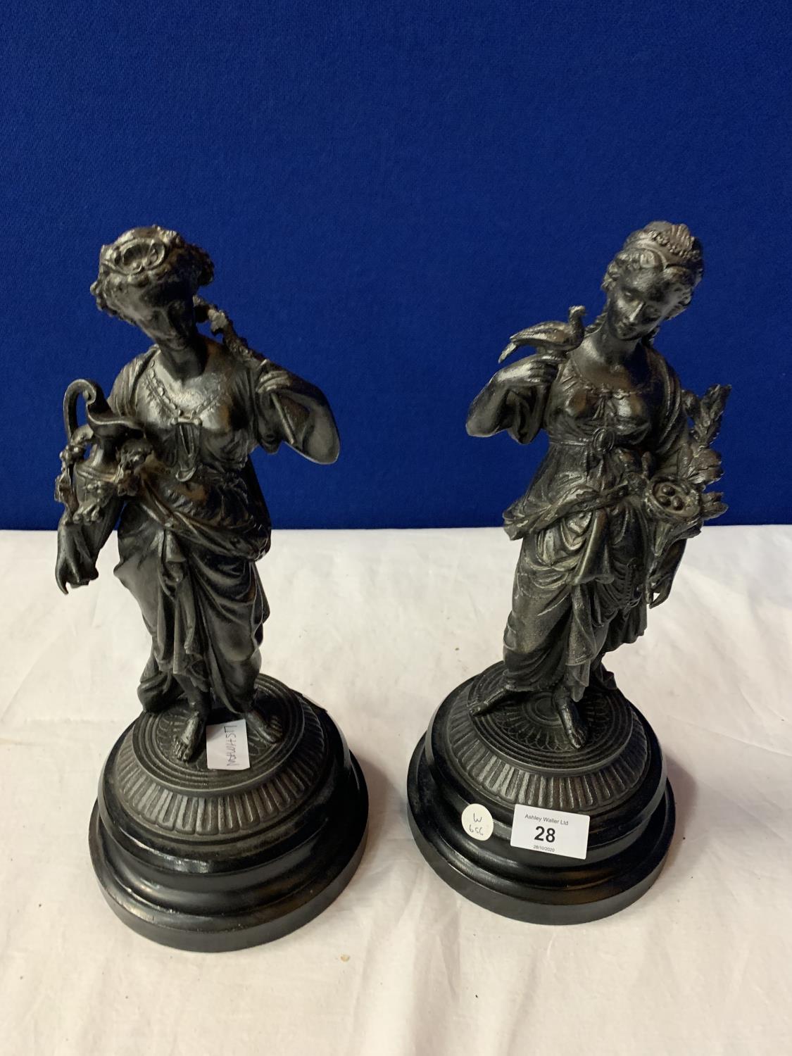 A PAIR OF SPELTER FIGURINES ON POLISHED WOODEN BASES