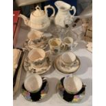 A COLLECTION OF TEAWARES TO INCLUDE A TEAPOT, LARGE JUG, SEVERAL CUPS AND SAUCERS AND SOME GLASS