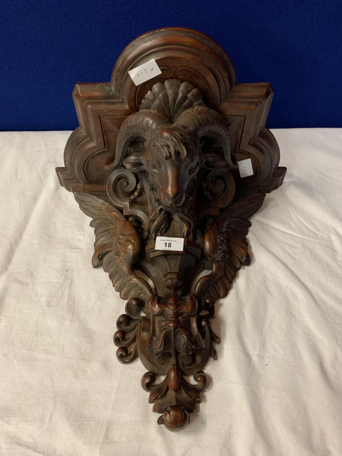 A CARVED WOODEN WALL SCONCE DEPICTING A RAM'S HEAD AND EAGLE WINGS (A/F TO SIDE)