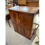 AN INLAID MAHOGANY COCKTAIL CABINET WITH FOUR DOORS AND MIRRORED SLIDE