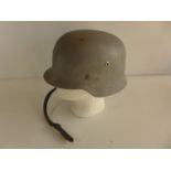 A GREY PAINTED GERMAN HELMET WITH LEATHER LINER