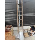 A TWO SECTION 18 RUNG WOODEN LADDER AND A ROLL OF POLYTHENE