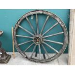 A VINTAGE CART WHEEL WITH BRASS HUB CAP