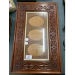 A CARVED WOODEN WALL FRAME FOR A TRIO OF PICTURES
