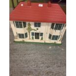 A VINTAGE 1950S DOLLS HOUSE WITH SLIDING METAL FRONTAGE