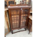 AN OAK BOOKCASE WITH TWO GLAZED PANEL DOORS AND LOWER STRETCHER RAIL