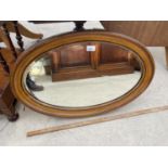 AN OVAL MAHOGANY BEVEL EDGE MIRROR