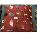 A CUSHION OF BROOCHES TO INCLUDE A YELLOW METAL SWAN AND A YELLOW METAL DOLPHIN