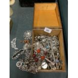 A WOODEN BOX CONTAINING AN ASSORTMENT OF WHITE METAL COSTUME JEWELLERY