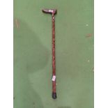 A CARVED WOODEN WALKING STICK FEATURING A CAT HANDLE