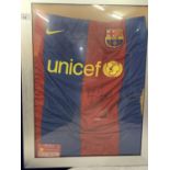 A FRAMED AND SIGNED BARCALONA FOOTBALL SHIRT BLEIEVED TO BE FROM THE 2009 SEASON. NO COA