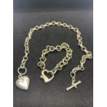 A HEAVY SILVER NECKLACE AND BRACELET WITH HEART DESIGN