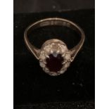 A 9 CARAT GOLD DRESS RING WITH RED AND CLEAR STONES