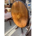 A VICTORIAN TILT TOP INLAID MAHOGANY DINING TABLE ON CARVED CENTRAL SUPPORT