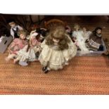 A LARGE ASSORTMENT OF PORCELAIN HEAEDED DOLLS TO INCLUDE ANITA A SKATING DOLL AND A LARGE DOLL ON