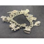 A SILVER CHARM BRACELET WITH SIXTEEN CHARMS