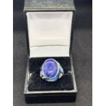 A BOXED SIGNED SILVER RING WITH A LARGE BLUE STONE AND DECORATIVE SHOULDERS IN ENAMEL AND COLOURED