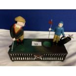 A CAST IRON MONEY BOX WITH A MOVABLE GOLFER AND CADDY