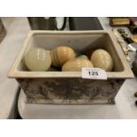 A CERAMIC BOX CONTAINING A QUANTITY OF MARBLE EGGS