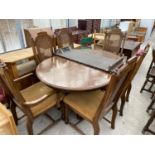 A CONTINENTAL STYLE EXTENDING DINING TABLE AND SIX DINING CHAIRS WITH CANE BACKS (4+2)
