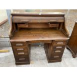 AN EARLY 20TH CENTURY TWIN PEDESTAL OAK ROLL-TOP DESK ENCLOSING NINE DRAWERS AND TWO SLIDES