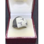 A BOXED SILVER RING WITH WHITE ENAMEL AND MARCASITE DECORATION