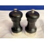A PAIR OF EBONY AND HALLMARKED SILVER SALT AND PEPPER MILLS