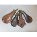FOUR COPPER AND BRASS POWDER FLASKS, LENGTHS 20CM TO 24CM