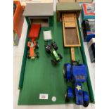 A WOODEN FARM LAYOUT WITH THREE TOY TRACTORS AND TRAILERS