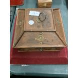 A DECORATIVE WOODEN BOX CONTAINING AN ASSORTMENT OF COSTUME JEWELLERY