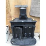 A CAST IRON STOVAX GAS WOOD BURNER WITH FLUE