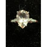 A 9 CARAT WHITE GOLD RING WITH A LARGE PALE PINK STONE AND DIAMOND CHIPS ON THE SHOULDER J/K