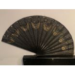A VINTAGE BOXED DECORATIVE FAN WITH BLACK AND GOLD DECORATION