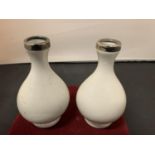A PAIR OF SILVER TOPPED WHITE VASES