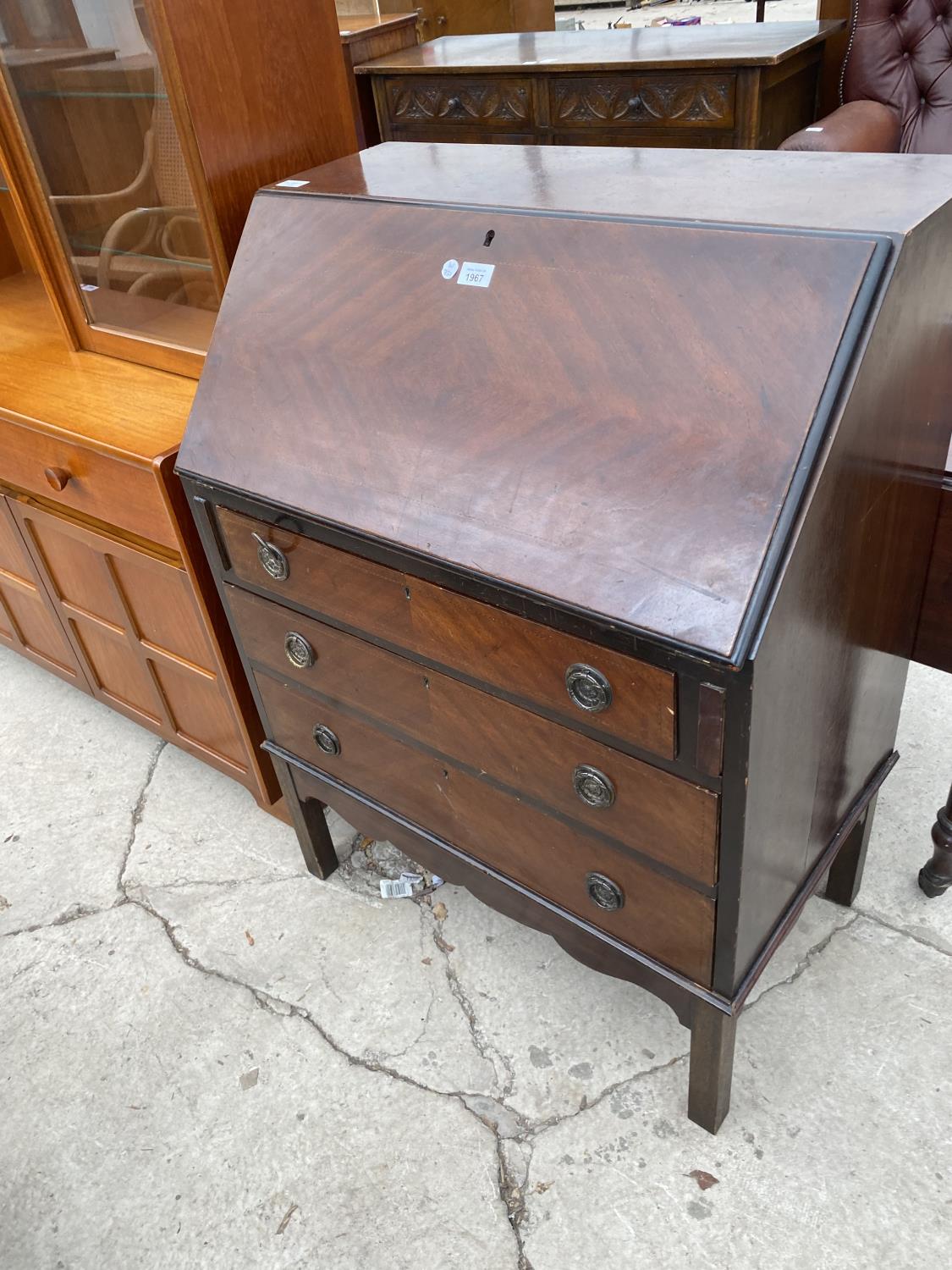 AN INLAID MAHOGANY BUREAU WITH FALL FRONT AND THREE DRAWERS