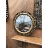 A GILT FRAMED CIRCULAR MIRROR