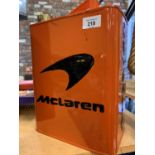 AN ORANGE MCLAREN PETROL CAN WITH BRASS LID