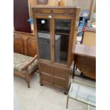 AN OAK CABINET WITH LOWER DOOR AND TWO UPPER GLAZED DOORS