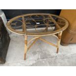 AN OVAL GLASS TOP COFFEE TABLE ON BAMBOO AND WICKER BASE, 33x20"