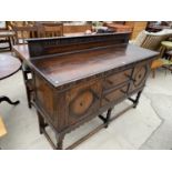 A GOTHIC STYLE OAK SIDEBOARD WITH TWO DOORS, TWO DRAWERS, LOWER STRETCHER RAIL AND UPPER SPLASHBACK