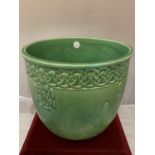 A PILKINGTONS LANCASTRIAN POTTERY GREEN JARDINERE WITH A MOULDED CELTIC DESIGN