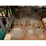 A LARGE QUANTITY OF GLASSWARE TO INCLUDE GREEN STEMMED WINE GLASSES AND SEVERAL BOWLS