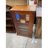 AN EARLY 20TH CENTURY MAHOGANY CABINET WITH SINGLE DOOR HAVING THREE MIRRORS AND GLAZED PANEL