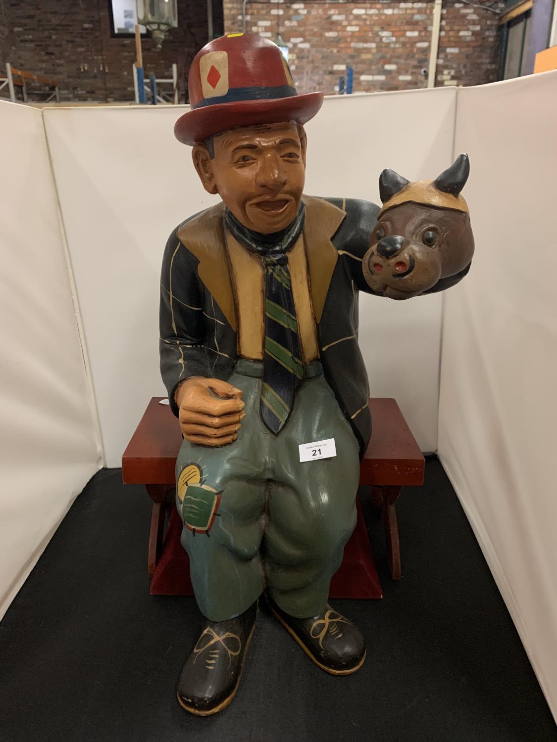 A LARGE RESIN CHARACTER ORNAMENT FEATURING A VENTRILOQUIST IN A BOWLER HAT SEATED ON A WOODEN BENCH