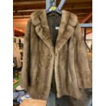 A SHORT BROWN FUR COAT WITH BRASS AND CORD BUTTON DETAIL