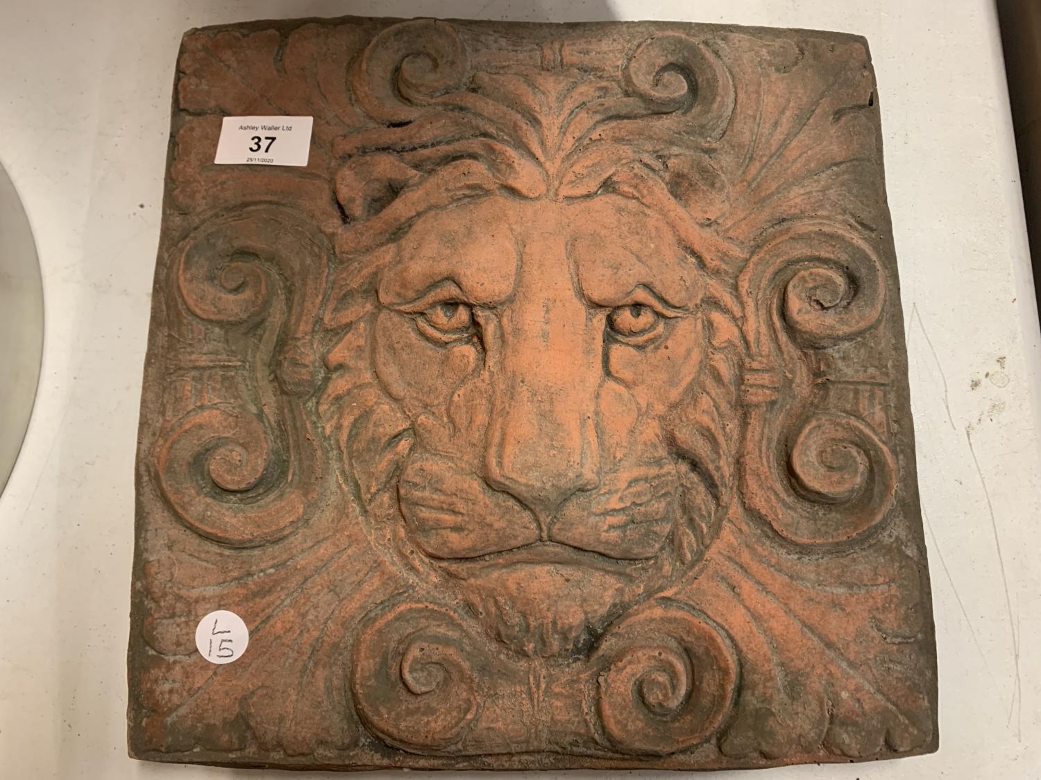 A SQUARE TERRACOTTA STONE TILE OF A LION'S HEAD IN RELIEF