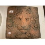 A SQUARE TERRACOTTA STONE TILE OF A LION'S HEAD IN RELIEF